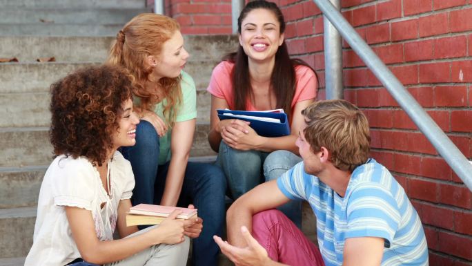 校园里，快乐的学生们坐在台阶上聊天