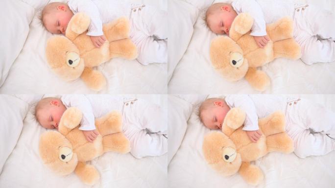 宝宝和泰迪熊在卧室里睡觉