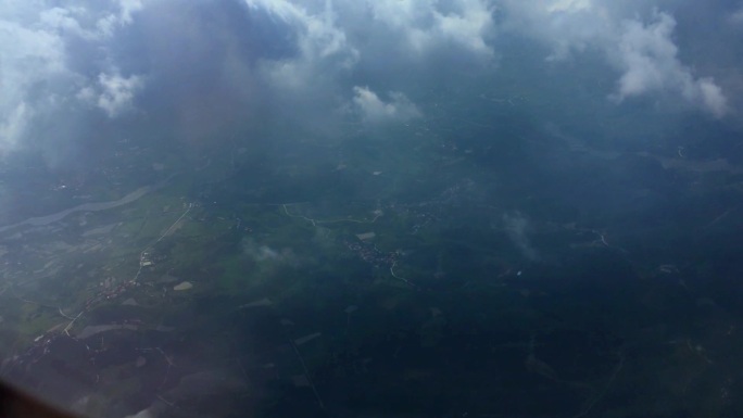 视频素材.飞机舷窗外的云朵和大地