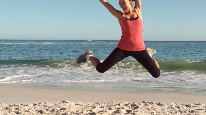 在海滩上锻炼的快乐女人的慢镜头