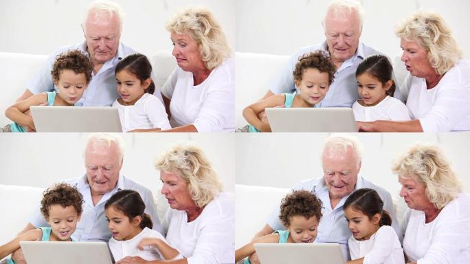 孩子和祖父母在家里使用笔记本电脑