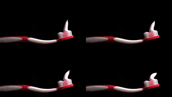 牙膏缓慢落在红色牙刷上特写