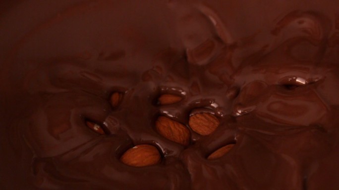 杏仁落入融化的巧克力中的慢动作