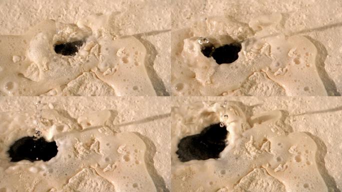 水滴落到沙子特写上
