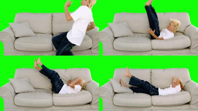 绿色屏幕下男孩跳到沙发上特写