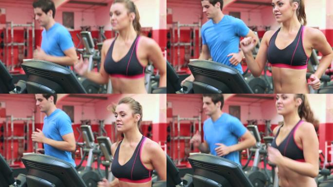 女人和男人在健身房的跑步机上跑步