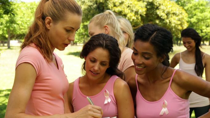 妇女们在一个阳光明媚的日子在公园里组织乳腺癌意识活动