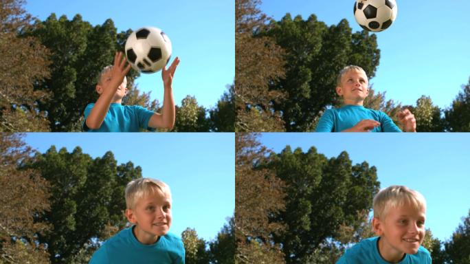 一个小男孩在用慢镜头顶着一个足球