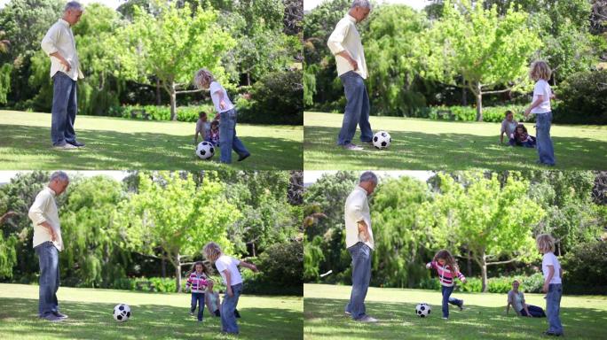 爸爸和他的孩子们在公园里踢足球特写