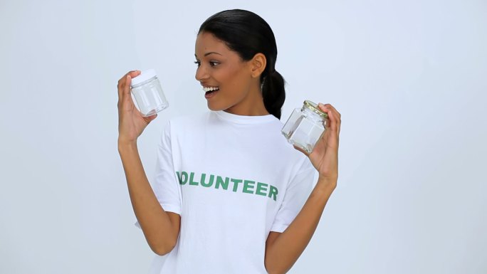 志愿者女生拿着两个罐子展示给镜头特写