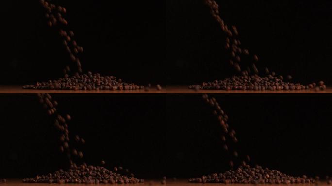 在慢镜头中，胡椒粒倒在黑色背景上