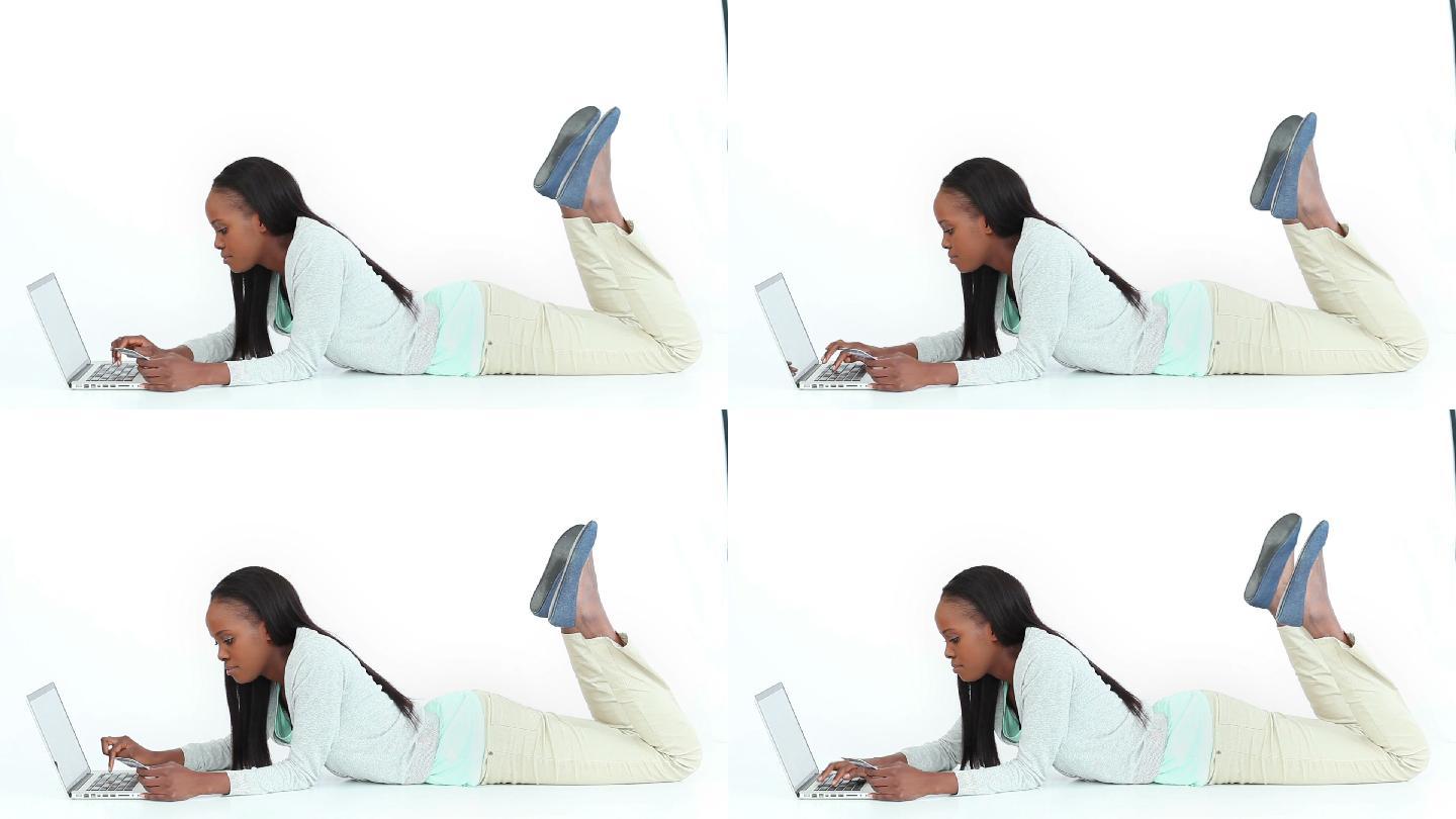 女人趴在白色背景下用电脑特写