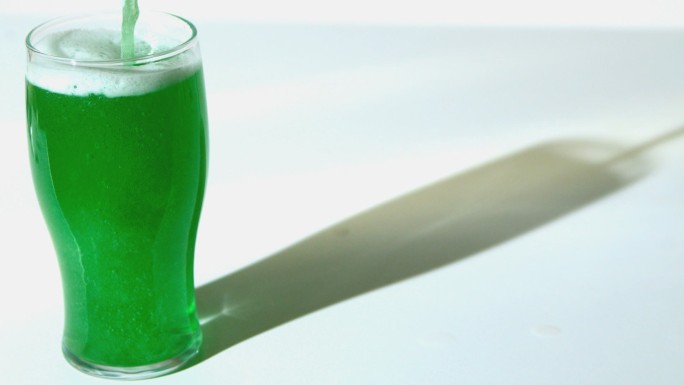 将绿色液体倒入玻璃杯中特写
