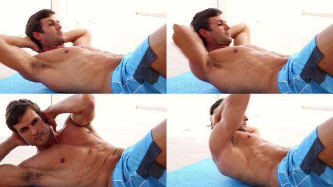 健身男赤裸上身在健身房做仰卧起坐