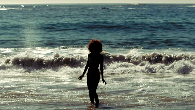 在慢镜头中，一个敏感的女人走进了大海