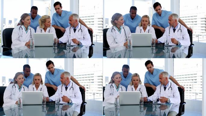 一群医生在会议室里一起使用笔记本电脑