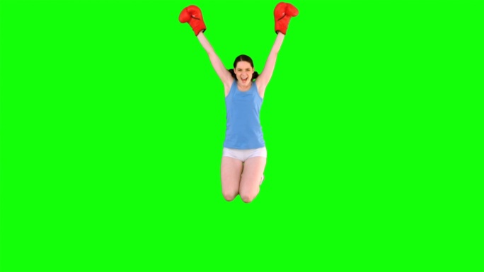 绿色背景下女人穿着运动衣打拳特写