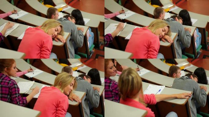 在大学的讲堂里，学生在课桌上睡觉