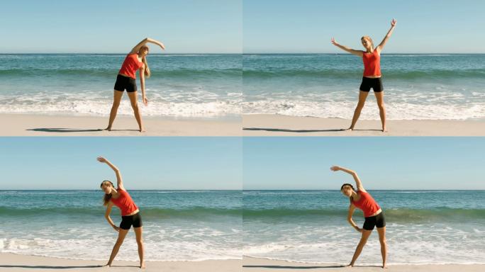 迷人的女人做伸展运动在海滩上的慢动作