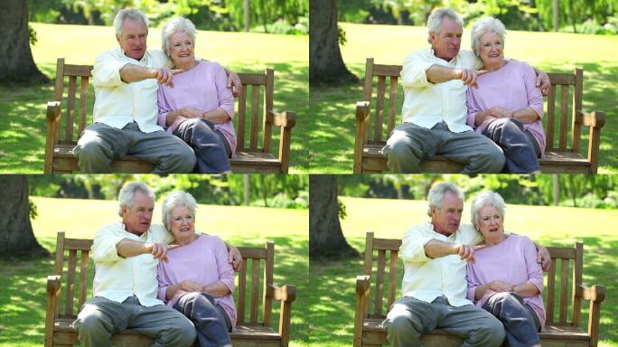 一对老夫妇坐在长椅上聊天特写