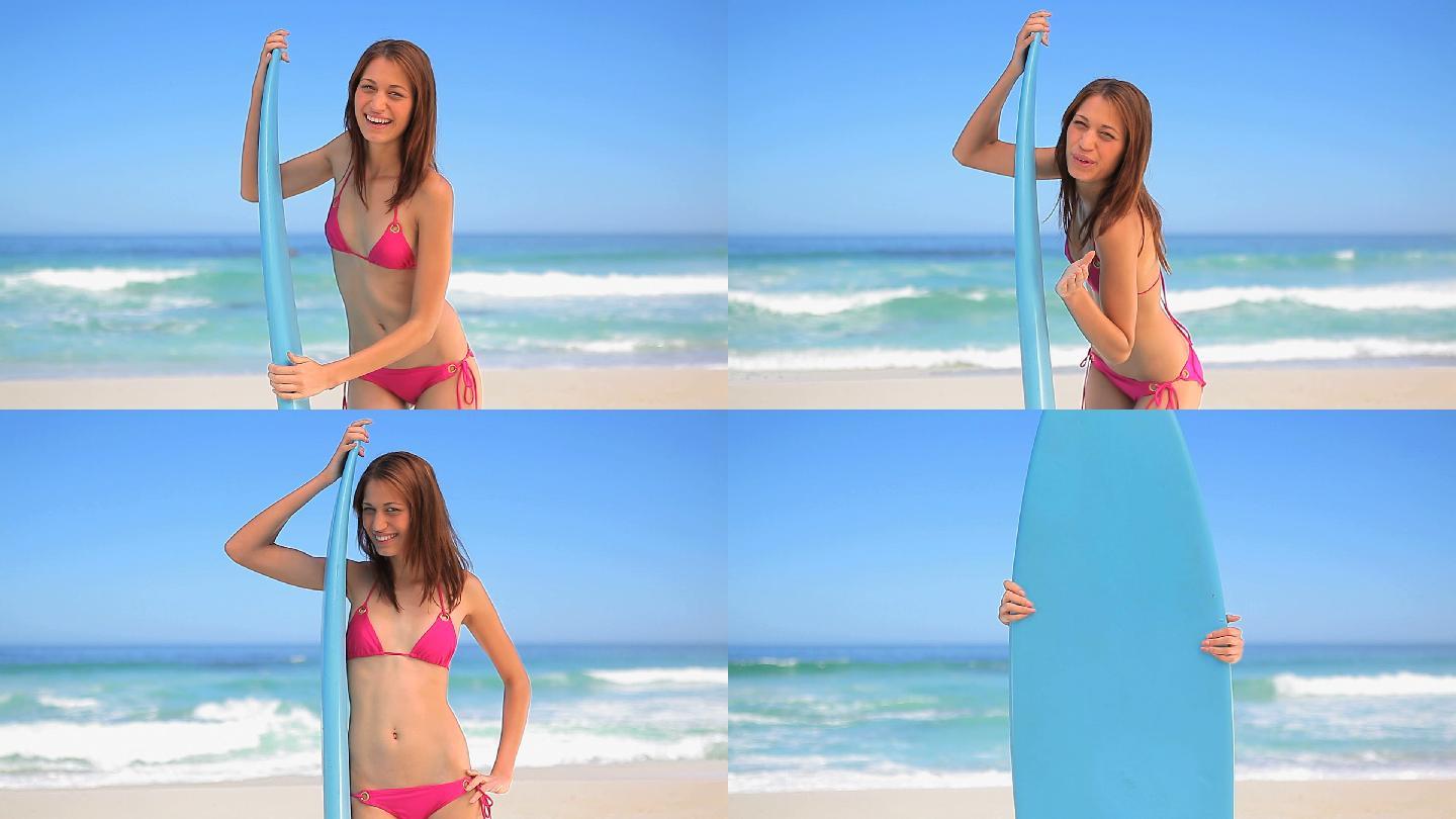 女人拿着冲浪板站在海边特写