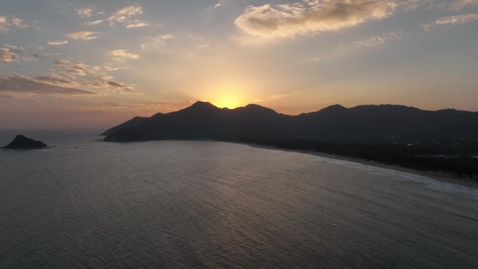 深圳西涌旅游度假区航拍海边山的背后是夕阳