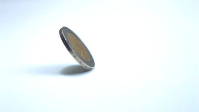 一枚欧元硬币在桌面上旋转特写