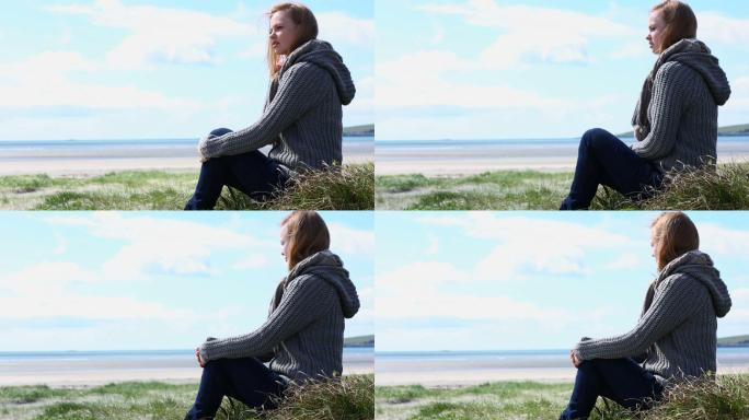 女人坐在海滩上看着大海