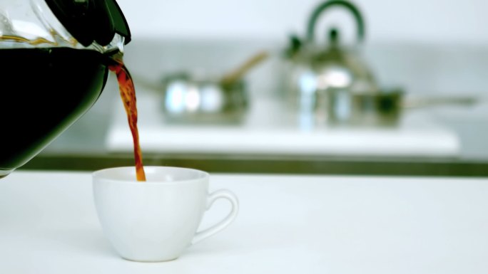 厨房里的黑咖啡正被倒进咖啡杯里