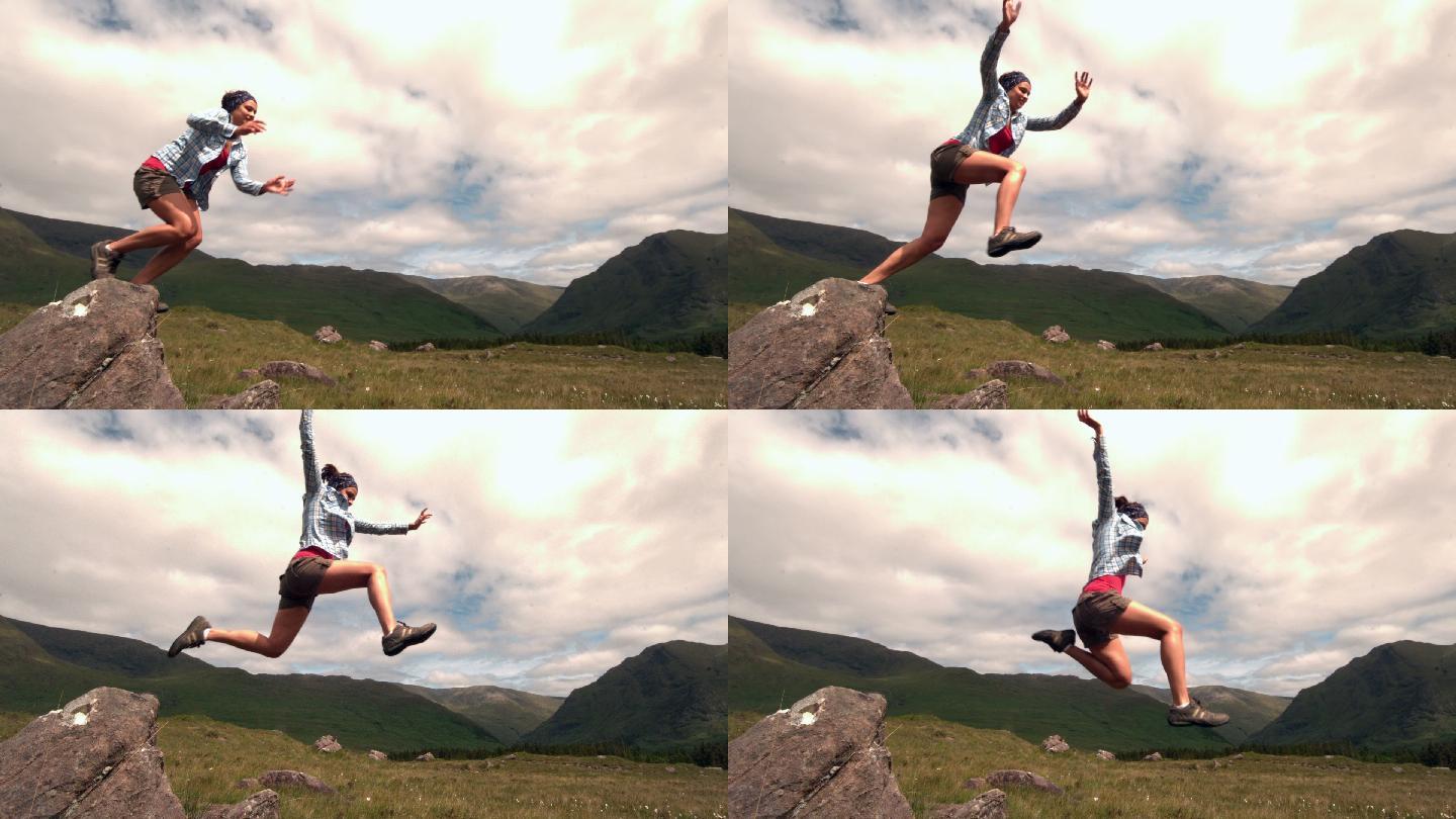运动女子在乡村从岩石上跳下来的慢镜头