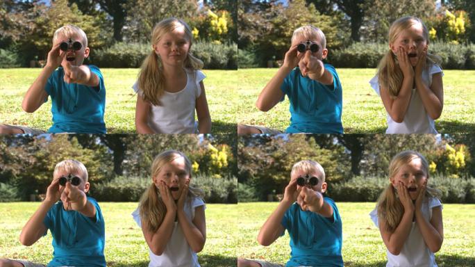 哥哥拿着双筒望远镜向妹妹慢镜头展示着什么