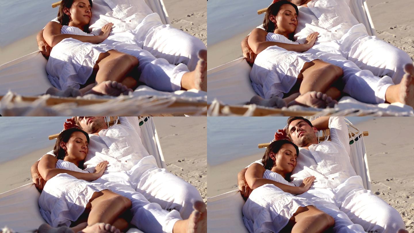 一对情侣在海滩的吊床睡觉特写