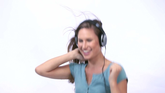 女人在白色背景下戴着耳机跳舞特写