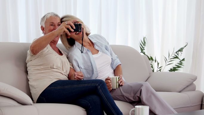 成熟的女人一起在客厅的沙发上拍照
