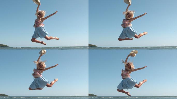 迷人的金发女郎拿着草帽在海滩上跳的慢镜头