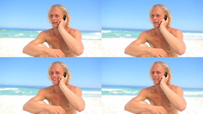 男人坐在沙滩上打电话特写