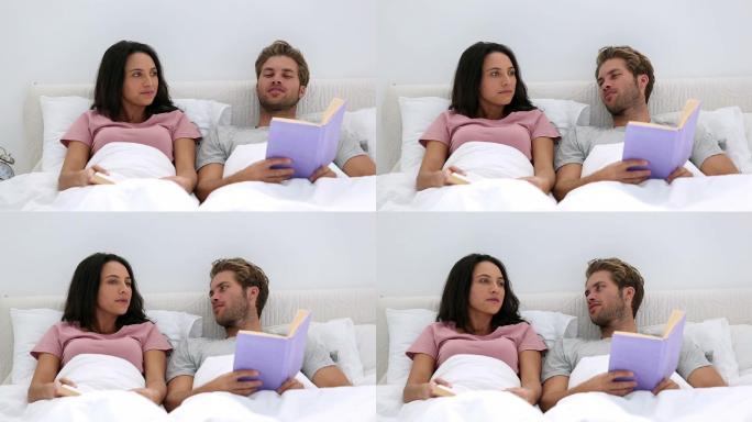 一对夫妇躺在床上看书特写