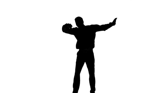 一个人的轮廓跳跃和提高腿在白色的背景在慢动作