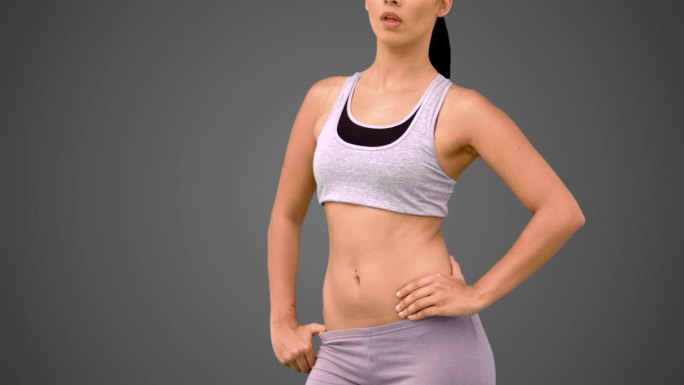 女人穿着运动服在灰色背景下锻炼特写