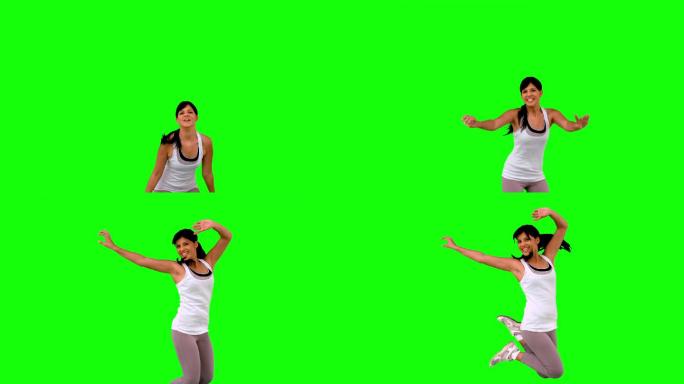 女人在绿色背景下举起手跳跃特写