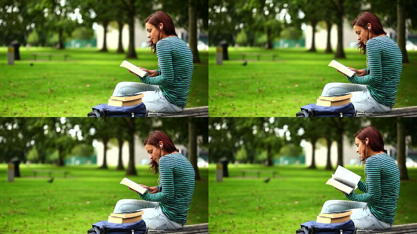 一个学生坐在长椅上看书特写