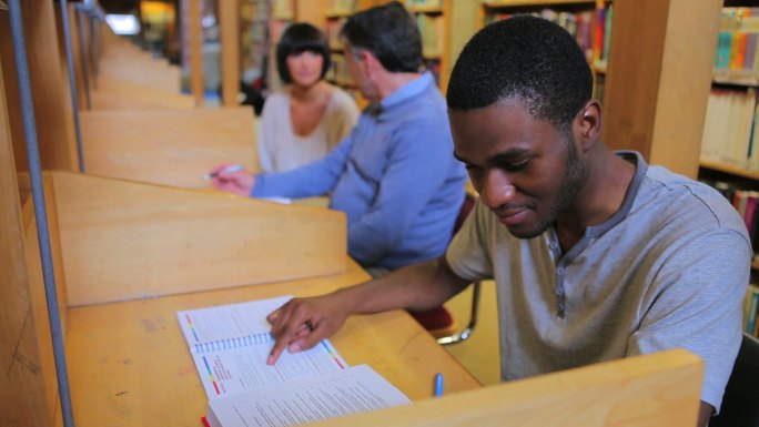 成熟的学生在大学的图书馆里学习和交谈