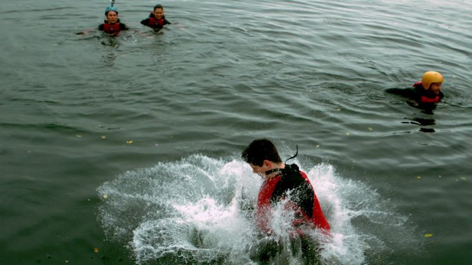 一个穿着潜水衣的人在湖里慢慢翻筋斗
