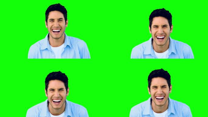绿色背景下男人看镜头大笑特写