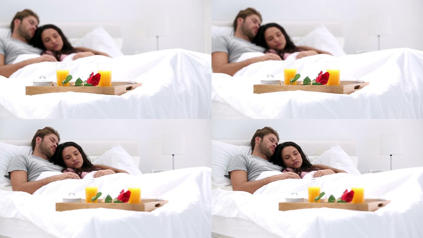 Couple napping after breakfast in bed at home with