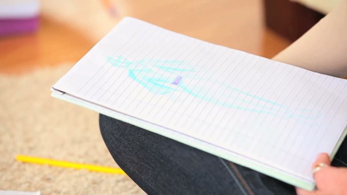 女人用彩色铅笔在笔记本上画画特写