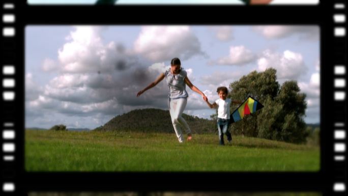 一个母亲和孩子在公园里玩的电影卷以黑色为背景