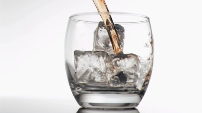 威士忌倒进装满冰块的杯中特写