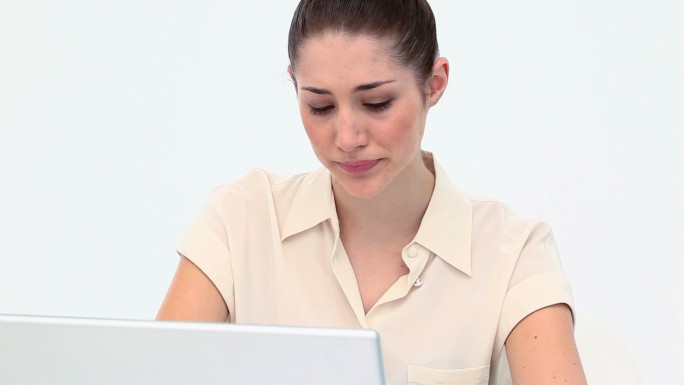 沮丧的年轻女子在白色背景下使用笔记本电脑