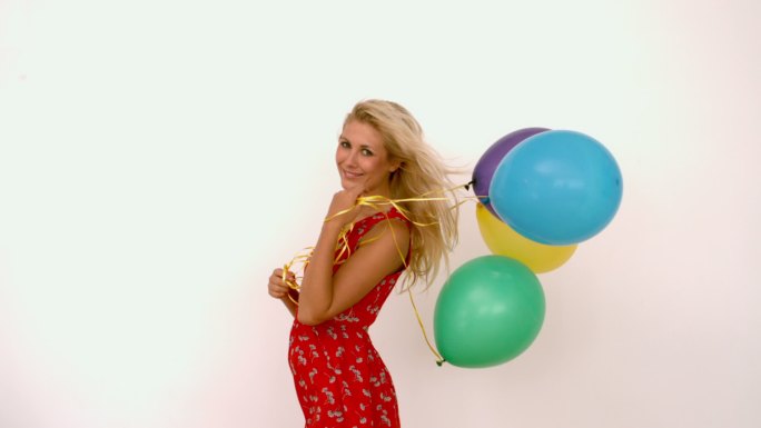 一个女人拿着彩色气球微笑特写
